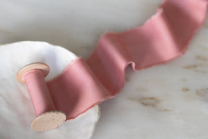 handmade and hand dyed with a hand torn frayed edge on a wooden spool