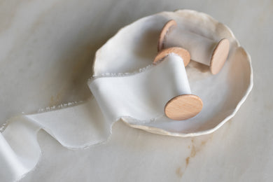 handmade and hand dyed with a hand torn frayed edge on a wooden spool