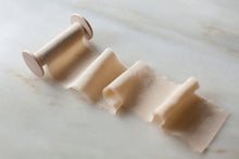 Load image into Gallery viewer, handmade and hand dyed silk ribbon in taupe creme brulee, on a wooden spool