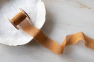 Handmade and hand dyed with all natural dyes. 100% silk ribbon with a delicately hand torn edge, sent on a wooden spool.